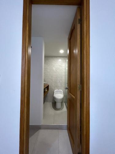 een badkamer met een toilet en een deur open bij Apartamento Coveñas in Coveñas