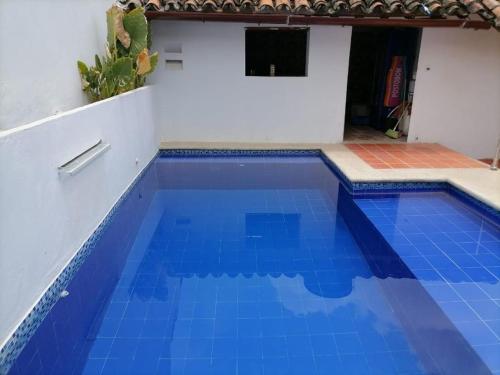 een zwembad met blauw water in een huis bij HOTEL CASA ALEMAN EN MOMPOX CON PARQUEADERO Y PISCINA CENTRO HISTORICOo in Mompós