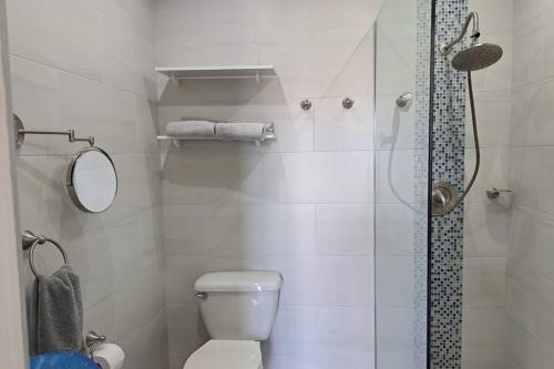a white bathroom with a shower and a toilet at Beautifully renovated villa close to the beach in Jolly Harbour