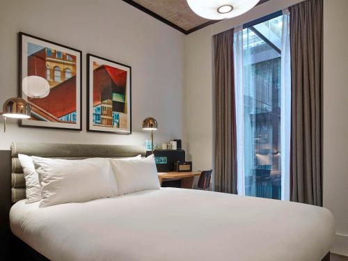 a bedroom with a bed and a large window at TRIBE London Canary Wharf in London