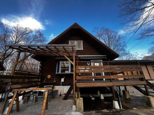 a log cabin with a lot of tables in front of it at 森の中の大型ログハウス最大16名可ペット同伴OkコテージLog in Nasu