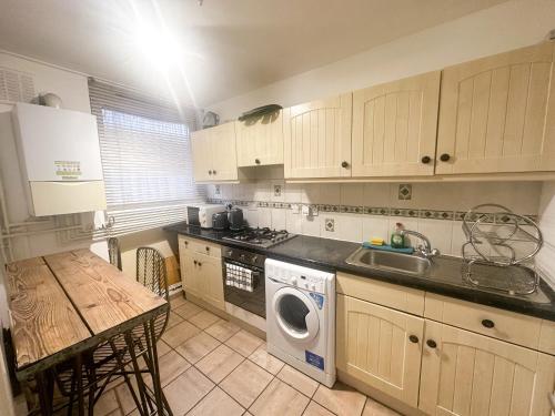 a kitchen with a washing machine and a sink at Aldgate flats in London