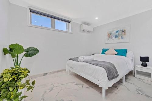 biała sypialnia z łóżkiem i oknem w obiekcie Quiet Elevated Serene Home w mieście Merrylands