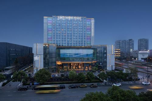 a large glass building with cars in a city at Crowne Plaza Chengdu Wuhou by IHG in Chengdu