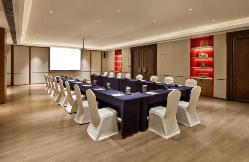 a conference room with a long table and white chairs at Crowne Plaza Chengdu Wuhou by IHG in Chengdu