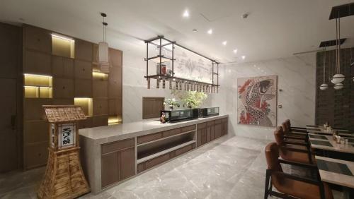 a kitchen with a counter and a dining room at Crowne Plaza Chengdu Wuhou by IHG in Chengdu