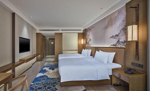 a hotel room with a large bed and a television at Crowne Plaza Chengdu Wuhou by IHG in Chengdu
