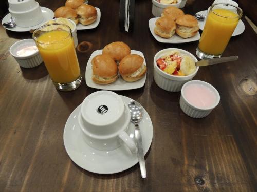 une table en bois recouverte de assiettes de nourriture et de jus d'orange dans l'établissement RESIDENCIAL CARMANI, à Tacna