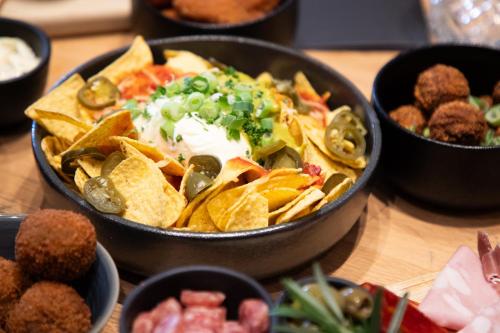 a bowl of chips and nachos on a table at Holiday Inn Express Hasselt by IHG in Hasselt