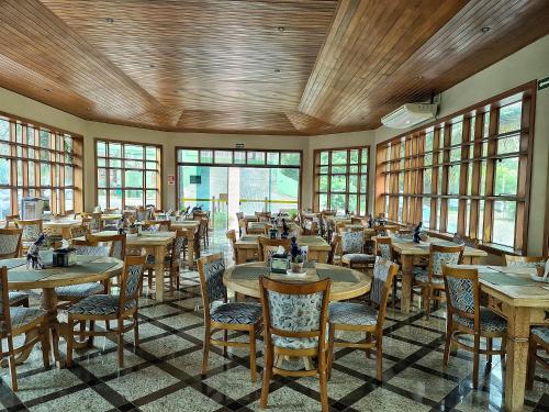 a dining room with tables and chairs and windows at Hotel Pousada Santa Rita in Ribeirão Preto