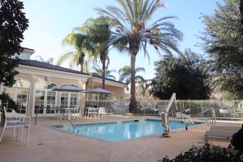 a swimming pool with palm trees and a building at Hilton Garden Inn Calabasas in Calabasas