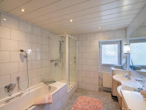 La salle de bains est pourvue d'une baignoire, d'une douche et d'un lavabo. dans l'établissement Föchlhaus am Marktgraben, à Hopfgarten im Brixental