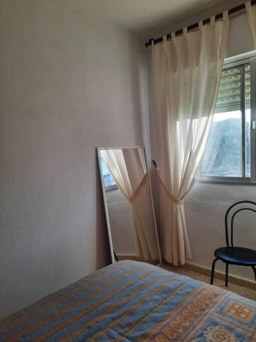 a bedroom with a bed and a window at Mi bonito apartamento del Portil in El Portil