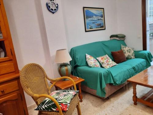 a living room with a green couch and a table at Mi bonito apartamento del Portil in El Portil