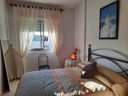 um quarto com uma cama e uma janela em Mi bonito apartamento del Portil em El Portil
