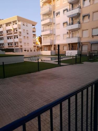 a walkway next to some buildings and a fence at Mi bonito apartamento del Portil in El Portil