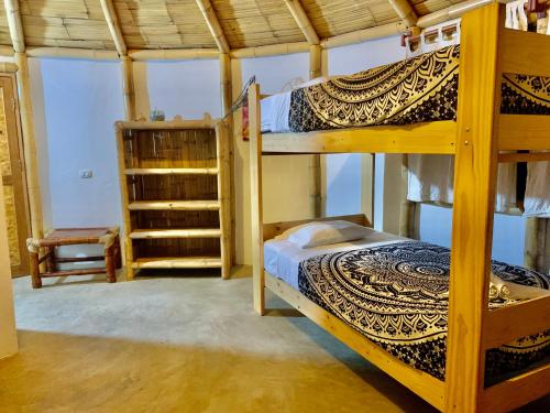 a bedroom with two bunk beds and a chair at Waltako Beach Culture in Canoas De Punta Sal