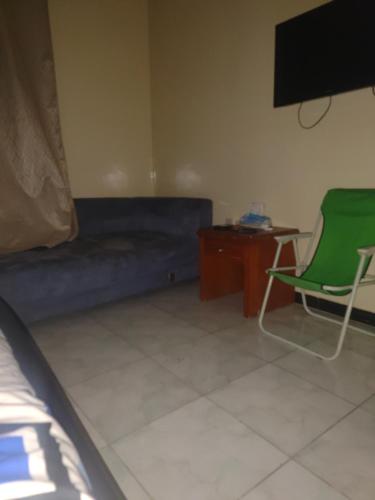 Habitación con sofá, silla y mesa. en Room Available Sharjah, en Sharjah