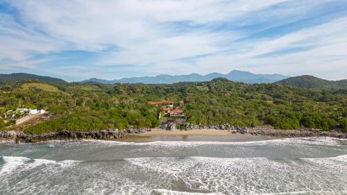 an aerial view of a beach with trees at Refugio de piedra - Troncones in Troncones