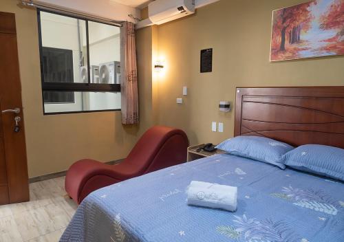 a bedroom with a bed and a chair and a window at Hotel Precursores in Lima