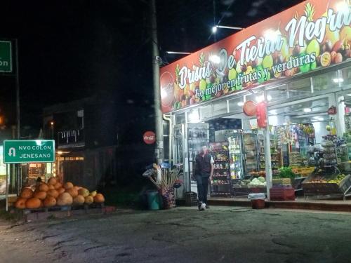 a man standing in front of a store at night at Hermosa Cabaña Campestre Puente Boyacá in Ventaquemada
