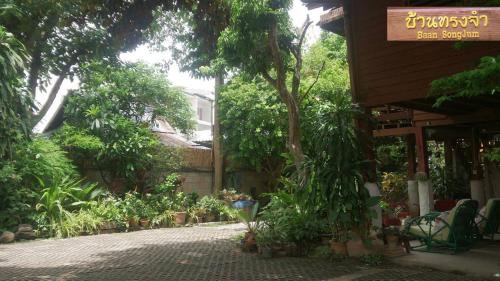 a garden with plants and trees and a building at Baan Songjum in Chiang Mai