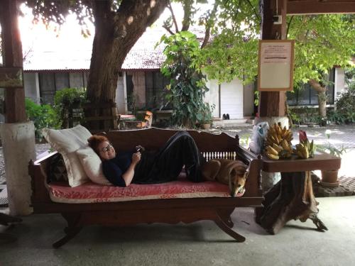 a man laying on a couch with a dog at Baan Songjum in Chiang Mai