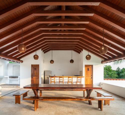 a dining room with a wooden table and benches at Refugio de piedra - Troncones in Troncones