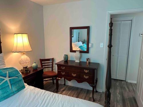 a bedroom with a bed and a desk and a mirror at Chesapeake Holiday House in Port Republic