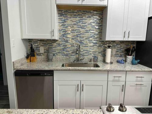 a kitchen with white cabinets and a sink at Chesapeake Holiday House in Port Republic