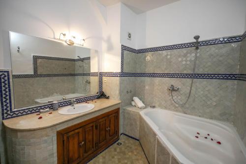 a bathroom with a tub and a sink and a mirror at La Perle de La Medina in Fez