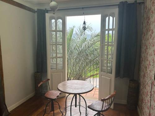 a table and chairs in a room with a window at Casa Temporada recanto de minas in Tiradentes