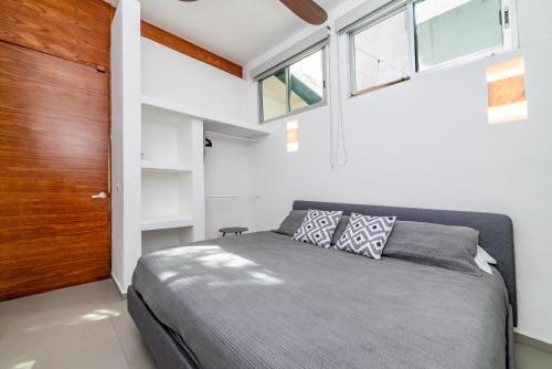 una camera da letto con un letto e una grande finestra di Relaxing 2 bedroom apartement in the center of tulum with private pool and terrace a Tulum