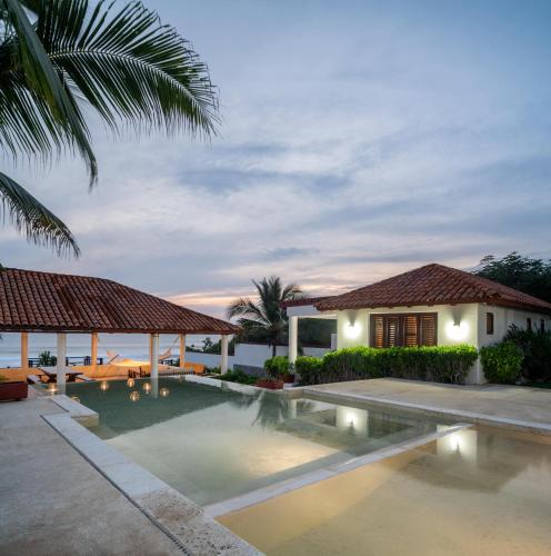 a swimming pool in front of a house at Refugio de piedra - Troncones in Troncones