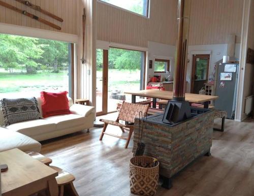 sala de estar con chimenea, sofá y mesa en Casa Malalcahuello Corralco, en Malalcahuello