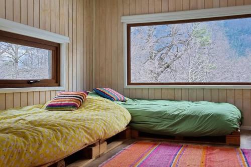 Bett in einem Zimmer mit einem Fenster und einem Bett sidx sidx sidx sidx in der Unterkunft Casa Malalcahuello Corralco in Malalcahuello