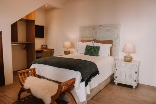 a bedroom with a large bed and a chair at Bärehuus Boutique Hotel in Antigua Guatemala