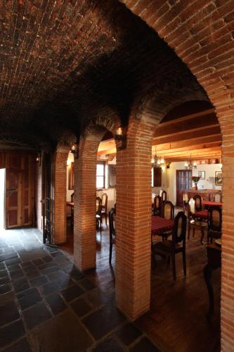 a room with brick walls and tables and chairs at Hotel Candelaria Antigua in Antigua Guatemala