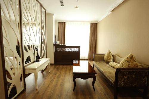 a living room with a couch and a table at CityBay Palace Hạ Long Hotel in Ha Long