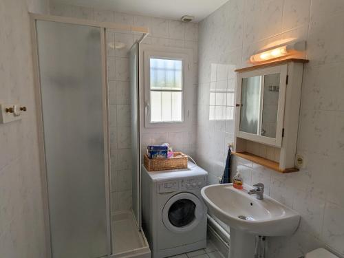 a bathroom with a washing machine and a sink at Gîte Donnery, 4 pièces, 6 personnes - FR-1-590-367 in Donnery