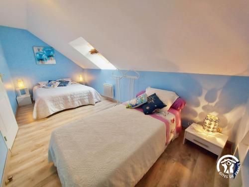 een slaapkamer met 2 bedden en een blauwe muur bij Gîte Carelles, 7 pièces, 12 personnes - FR-1-600-62 in Carelles