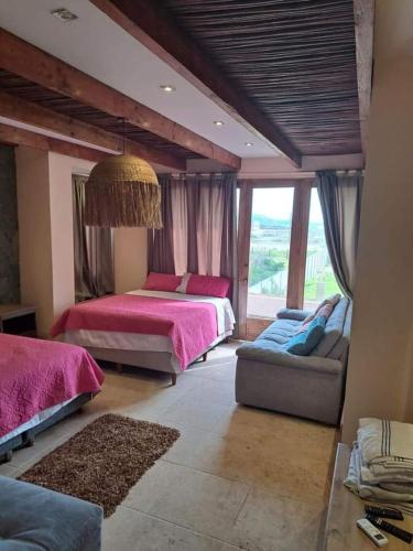 1 dormitorio grande con 2 camas y sofá en Cabaña Maria, en Santa Marta