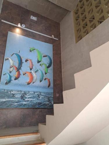 a painting of birds on a wall next to a staircase at Cabaña Maria in Santa Marta