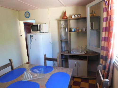 a small kitchen with a table and a refrigerator at ARCO IRIS in La Coronilla