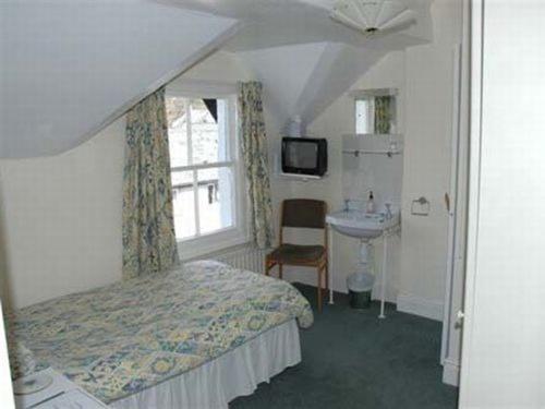 a bedroom with a bed and a sink and a window at Silverdale Guesthouse in Keswick
