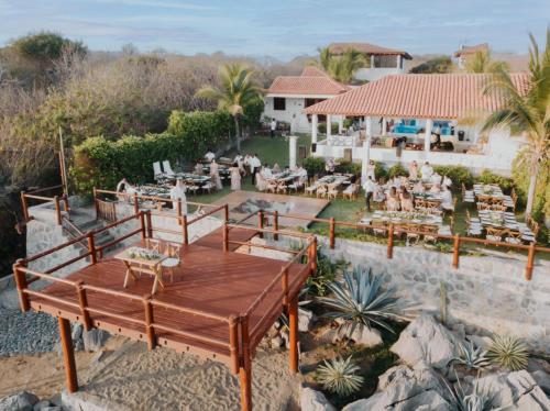 a patio with a table and chairs and a house at Refugio de piedra - Troncones in Troncones