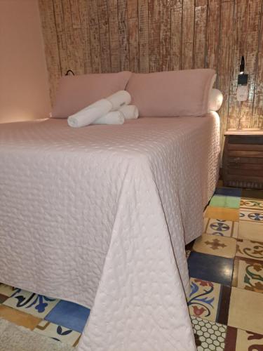 a white bed with a stuffed animal on top of it at Casa de Praia - meu lugar em Iriri in Anchieta