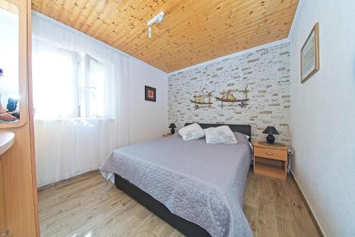 a bedroom with a bed and a brick wall at Apartments with a parking space Postira, Brac - 22159 in Postira
