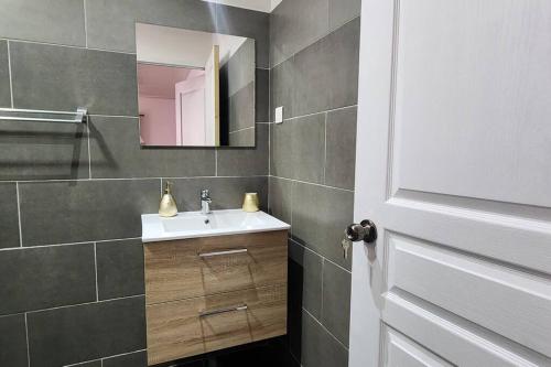 La salle de bains est pourvue d'un lavabo et d'un miroir. dans l'établissement Vaiana Home 1, à Taputapuapea