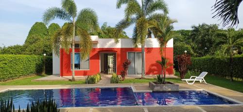 uma casa com piscina em frente a uma casa em Las Margaritas em Villavicencio